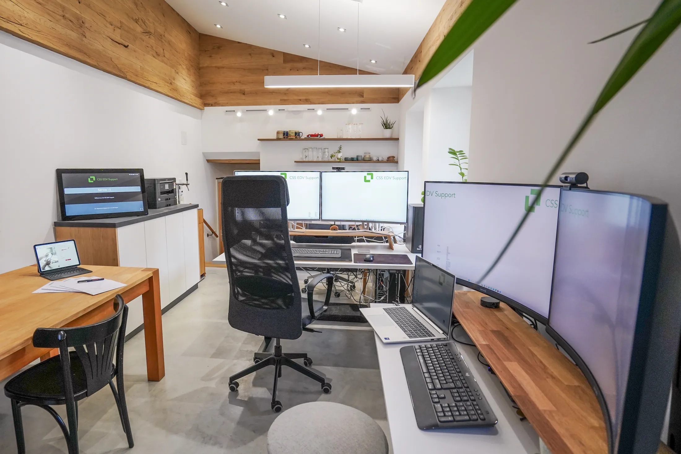 Blick ins Büro von CSS EDV Support mit Schreibtischen, Monitoren und einer Holzdecke